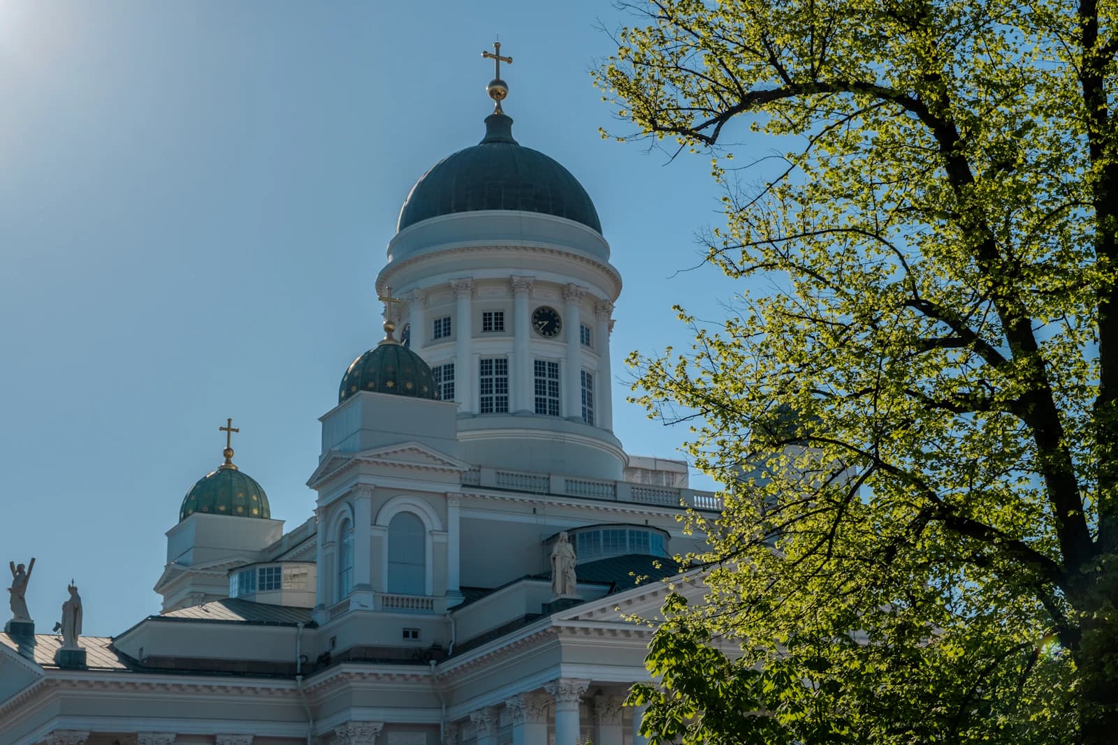 Helsinki Cathedral's white façade and green domes against a blue sky