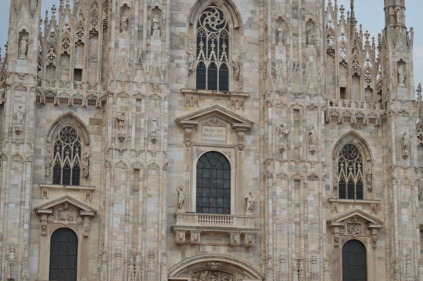 Gothic marble façade of Milan Cathedral filling the square
