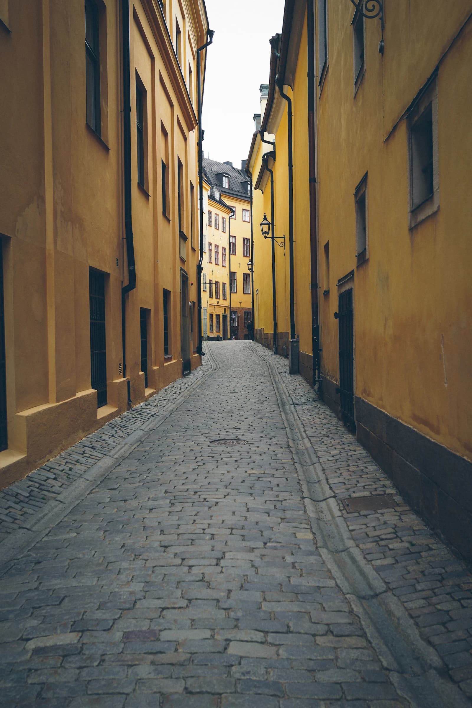 A cobbled lane between yellow houses in Stockholm's Gamla Stan